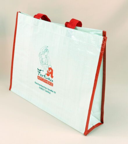 Gesund und Stilvoll: Weiße PP Woven Taschen von FORTUMA APOTHEKE mit roten Seiten.